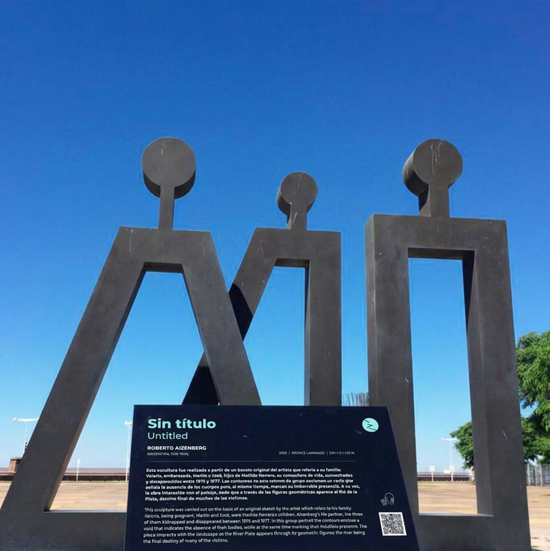 Escultura de tres figuras humanas en metal en Parque de la Memoria.